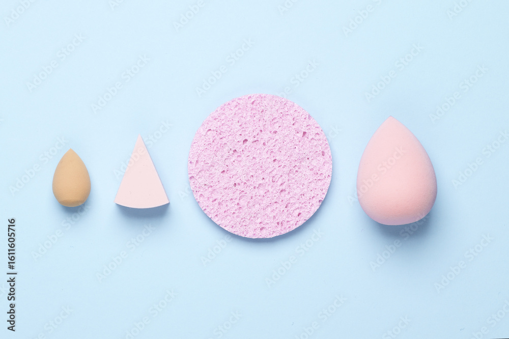 Fototapeta premium Remover sponge and make-up blenders on a blue background. Beauty concept