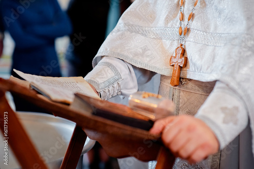 Fotografie An orthodox priest wearing ceremonial robes and holding a sacred book, shown during a ritual service, symbolizing faith, tradition, and religious observance