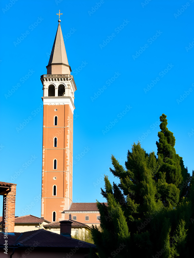 Fototapeta premium high tower Santa Anastasia in Verona. Blue sky and clear in the background, roofs and green trees near and around tawer
