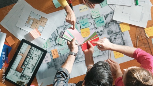 Foto Top down aerial view of interior designer team choosing color from palettes while architect engineer planning house construction from tablet and project plan at table with building plan