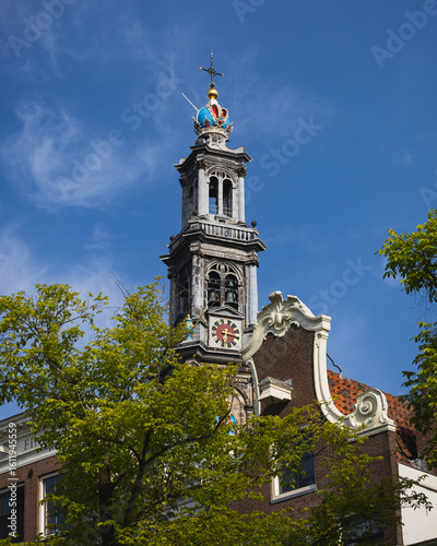 Photography View of Amsterdam's Westerkerk tower with a crown of the tree and a fragment of