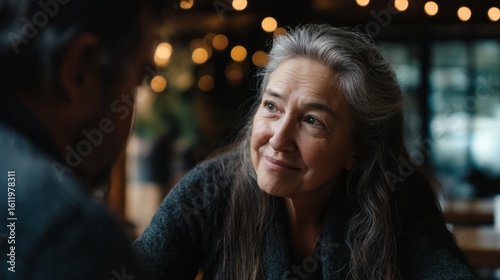 Mature woman gazes affectionately at companion during conversation.