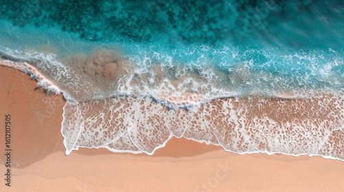 Aerial view of turquoise ocean waves washing onto sandy beach