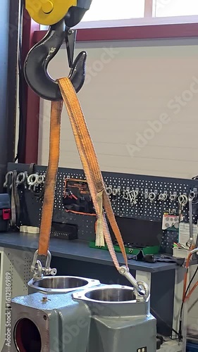 Moscow, Russia July 22, 2025. Worker securing heavy machinery with lifting straps for safe transport