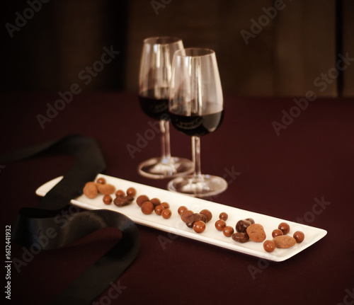 Assortment of chocolate covered nuts and red wine