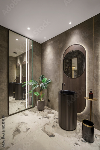 Quadro em tela Modern bathroom featuring a black pedestal sink, a backlit oval mirror, and a large potted plant next to a full-length mirror creating a reflection