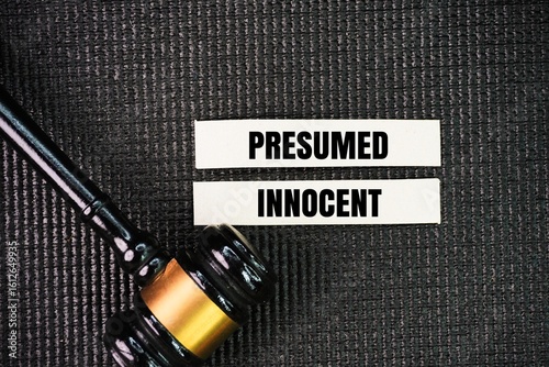 Judge's gavel and paper with the word presumed innocent. Any defendant in a criminal trial is assumed to be innocent until they have been proven guilty.