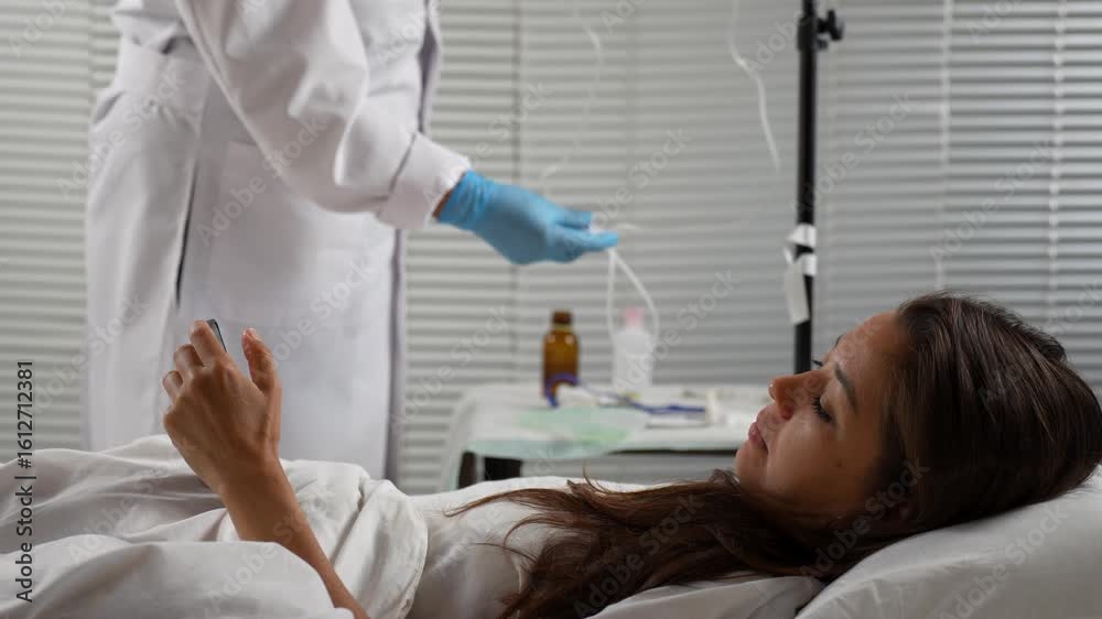 Patient Using Phone While Medical Professional Prepares IV Patient Using Phone While Medical Professional Prepares IV