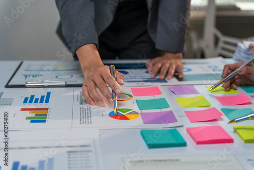 Quadro em tela Business team analyzing financial charts and graphs using colorful sticky notes