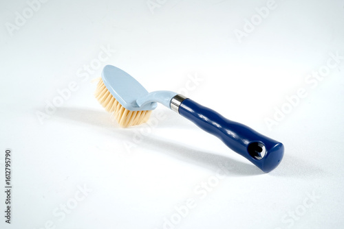 Hard bristle cleaning brush with long blue handle and ergonomic gray grip, isolated on white background