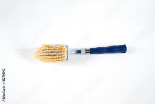 Hard bristle cleaning brush with long blue handle and ergonomic gray grip, isolated on white background
