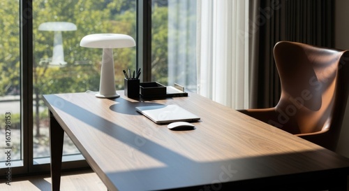 Modern wooden desk with a comfortable leather chair and a bright window view
