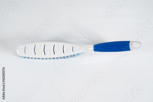 Hard bristle cleaning brush with long blue handle and ergonomic gray grip, isolated on white background