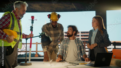 Fotografie Construction workers and architect reviewing blueprints on site