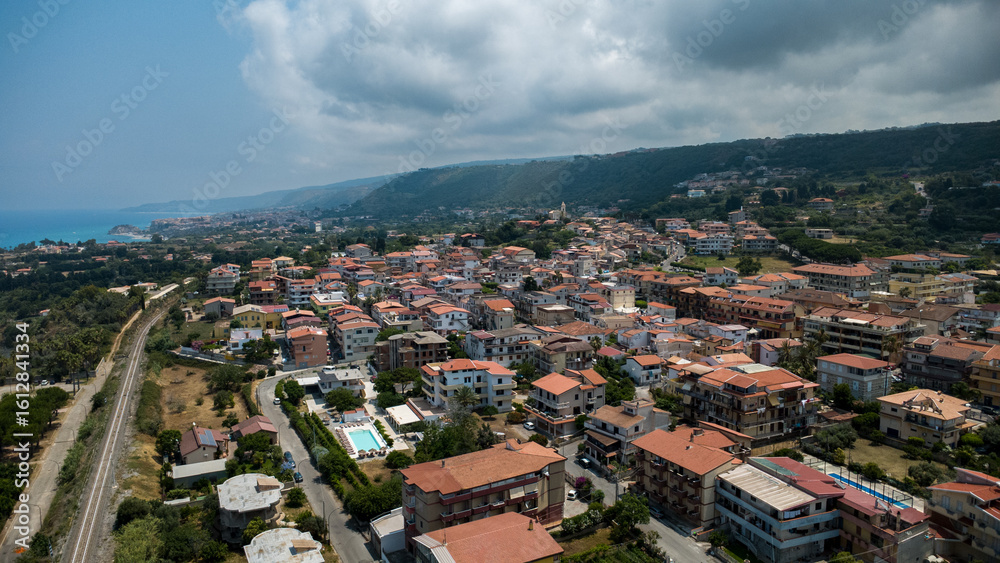 Fototapeta premium Red-Roofed Residential District with Lush Hillside – Panoramic View