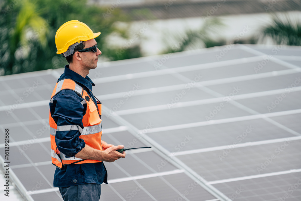Obraz premium Worker inspects solar panels on a rooftop in a residential area during daylight hours