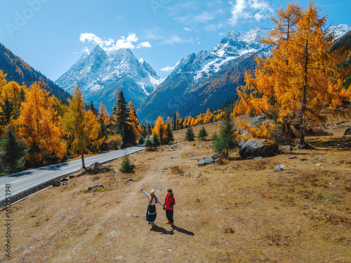Aerial view of  Couple tourist relaxing  at  Mount Siguniang national park with the Beautiful  snow mountains in autumn, Chengdu ,Sichuan in China.