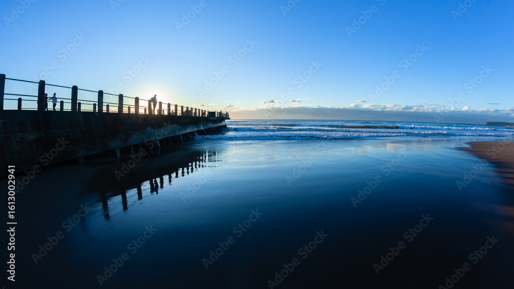 Fototapeta premium Beach Pier Jetty Waters Edge Sand Reflection Contrasts Horizon Sunrise.