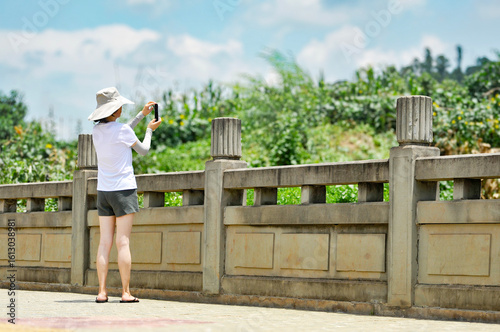 Beautiful Asian women in city park with mobile phone for photos
