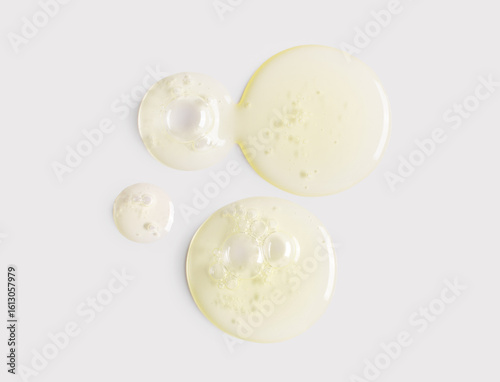 Foto round drops of serum gel texture cosmetic products on light background