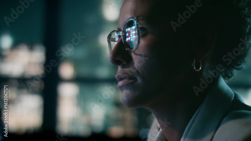 Close-up of female stock market analyst working in skyline office at night