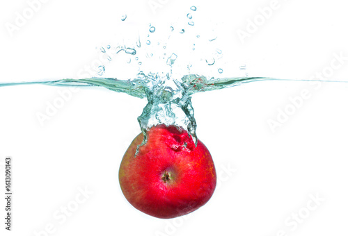 Red Apple Splashing Into Clear Water Creating Bubbles and Ripples