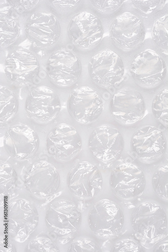 A high-angle, full-frame shot captures the textured surface of clear bubble wrap, showcasing its protective, translucent qualities as a packaging material