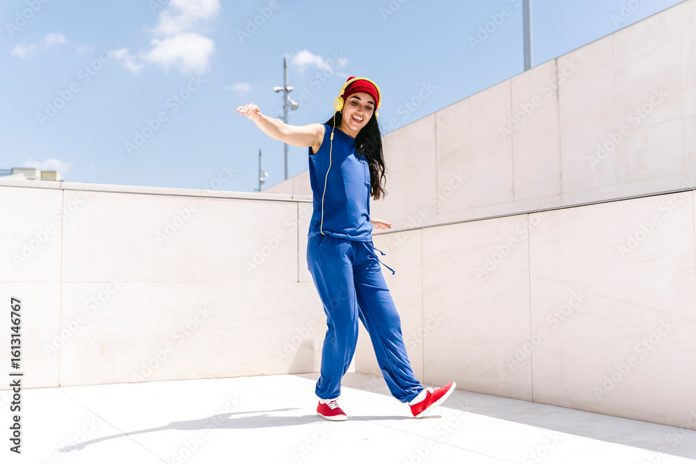 © VISTA by Westend61 - Person dancing outdoors in blue outfit with red shoes and hat © VISTA by Westend61 - Person dancing outdoors in blue outfit with red shoes and hat