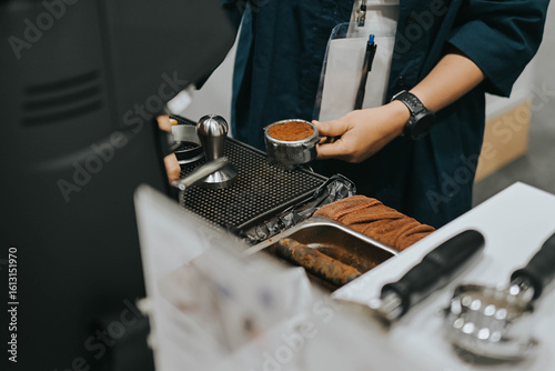 Εκτύπωση καμβά Close-up of hand Barista holding portafilter and coffee tamper making an espresso coffee