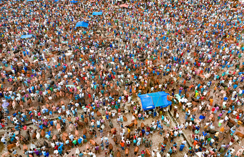 Aerial view of a sea of humanity, a vibrant tapestry of colors and movement, where people converge in a bustling marketplace, Mahasthan, Rajshahi Division, Bangladesh.