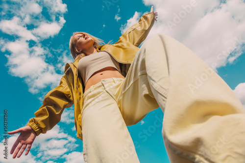 Stylish woman posing confidently outdoors in low angle view