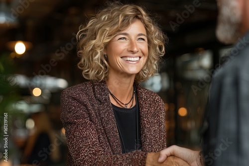 Welcoming Gesture: Professional Extending Hand Amid Indoor Crowd