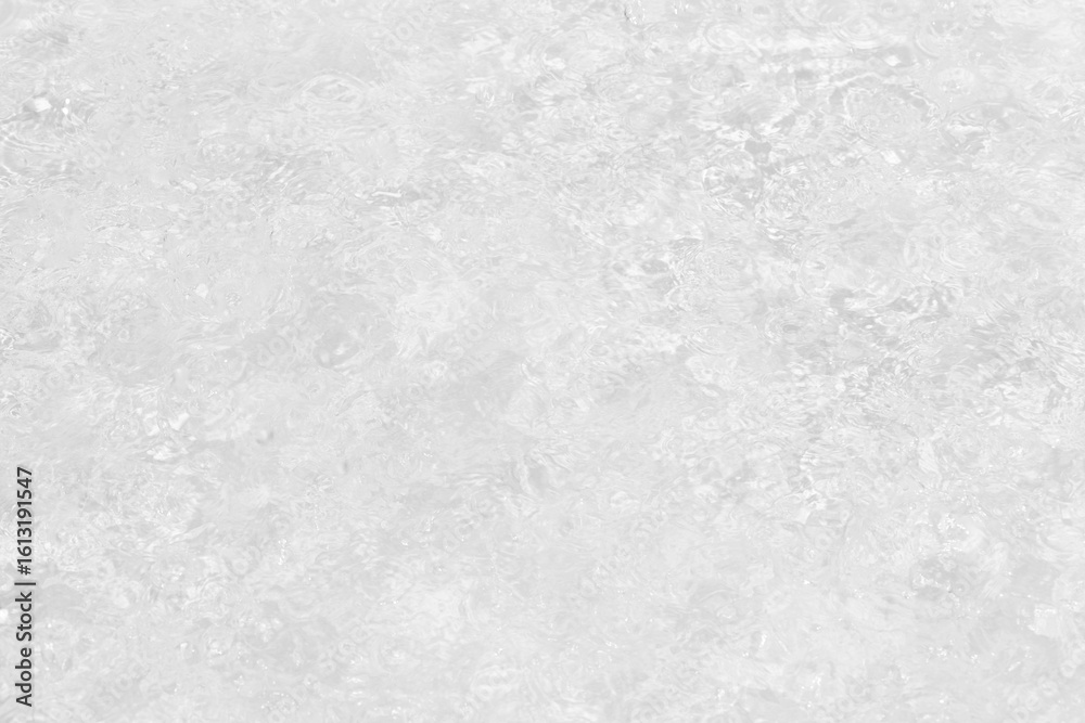 Obraz premium White water with ripples on the surface. Defocus blurred transparent white colored clear calm water surface texture with splashes and bubbles. Water waves with shining pattern texture background.