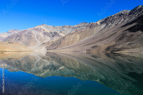 Fotografie Reflections of solitude—barren mountains mirrored in a tranquil lake