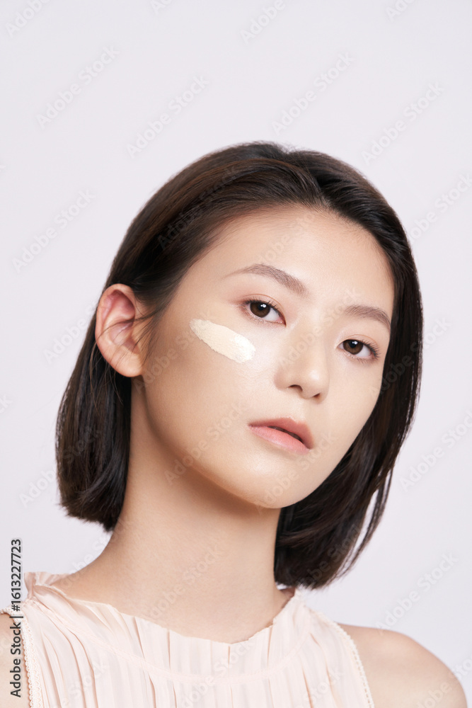 Close-up of a young woman applying makeup. Close-up of a young woman applying makeup.