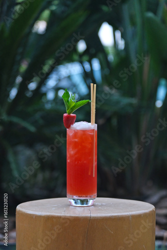 Strawberry mojito with tropical plants in the background