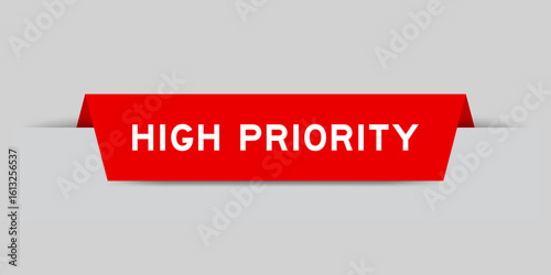 Red color inserted label with word high priority on gray background