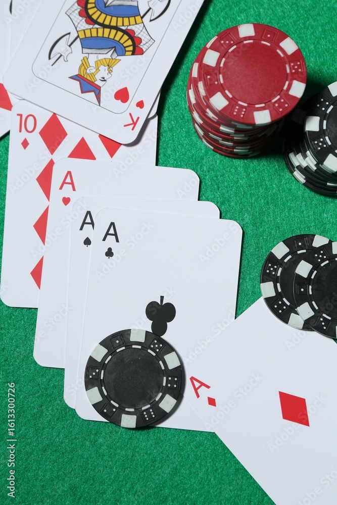 Fototapeta premium Casino chips and playing cards on green table, flat lay