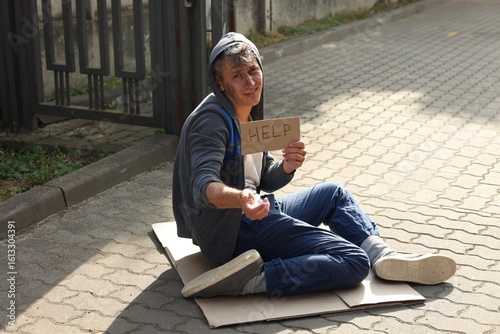 Schilderij op canvas Homeless man with sign Help begging for money on carton outdoors
