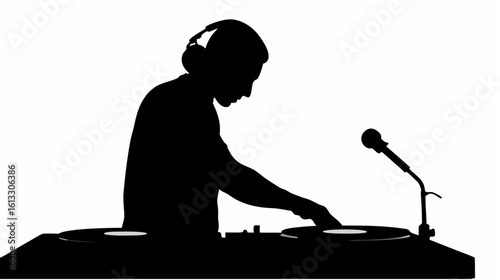Silhouette of dj with headphones playing music on turntables with microphone in a studio setting shown