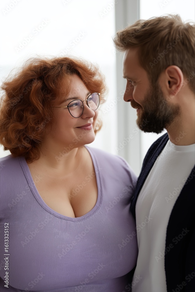 Fototapeta premium Happy caucasian couple smiling at each other in cozy setting