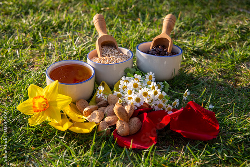 Assorted Foods and Flowers Arranged Outdoors on Green Grass