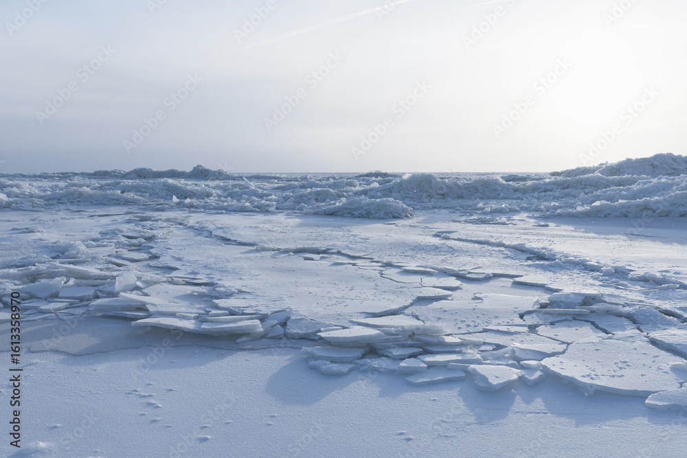 Obraz premium Frozen Arctic Landscape with Cracked Ice Under Blue Sky