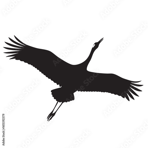 Black silhouette of a crane bird in flight with wings spread wide flying