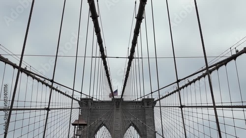 This video showcases a cloudy day in NYC, featuring the Brooklyn Bridge with pedestrians, highlighting the urban atmosphere and its grand structure