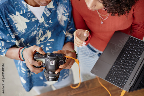Tableau sur toile Young adult Black woman and young adult Black man reviewing digital camera image