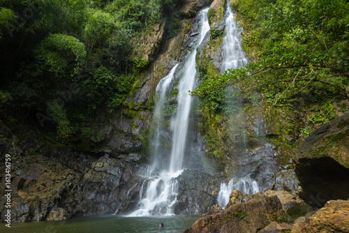 Waterfall in deep tropical rainforest with green rainy tree nature landscape