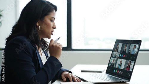 Woman in a suit at a video conference on her laptop