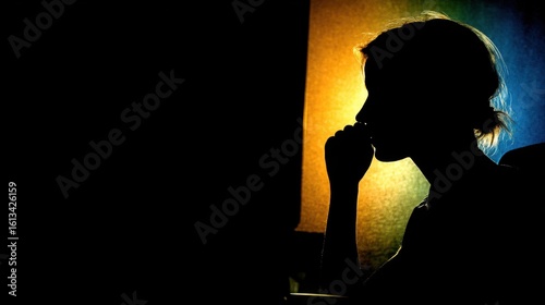 Silhouette of woman thinking by colorful window light