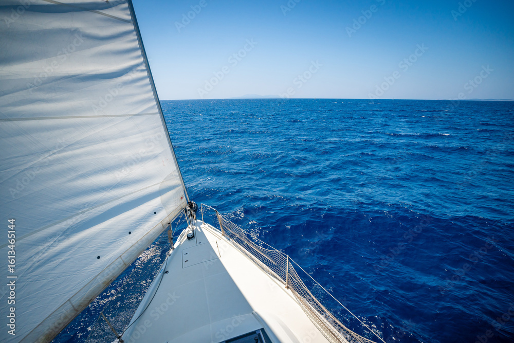 Obraz premium View from the mast down to the bow of a sailing yacht moving under full sails near Croatia. Freedom, adventure, yachting lifestyle and dynamic sea travel.